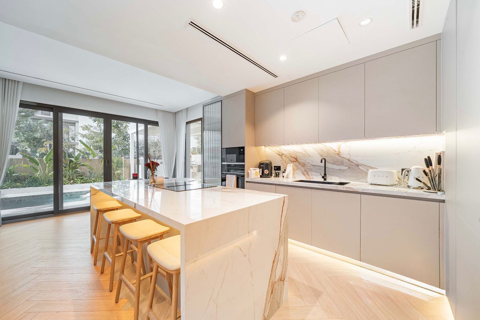 German kitchen with marble island, beige cabinets
